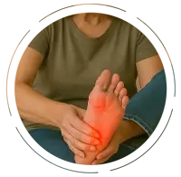 Older woman sitting on a beige chair, massaging her left foot with a pained expression, highlighting numbness and tingling with a red glow