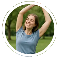 oung woman smiling joyfully while stretching her arms above her head in a green park, wearing a light blue T-shirt and jeans